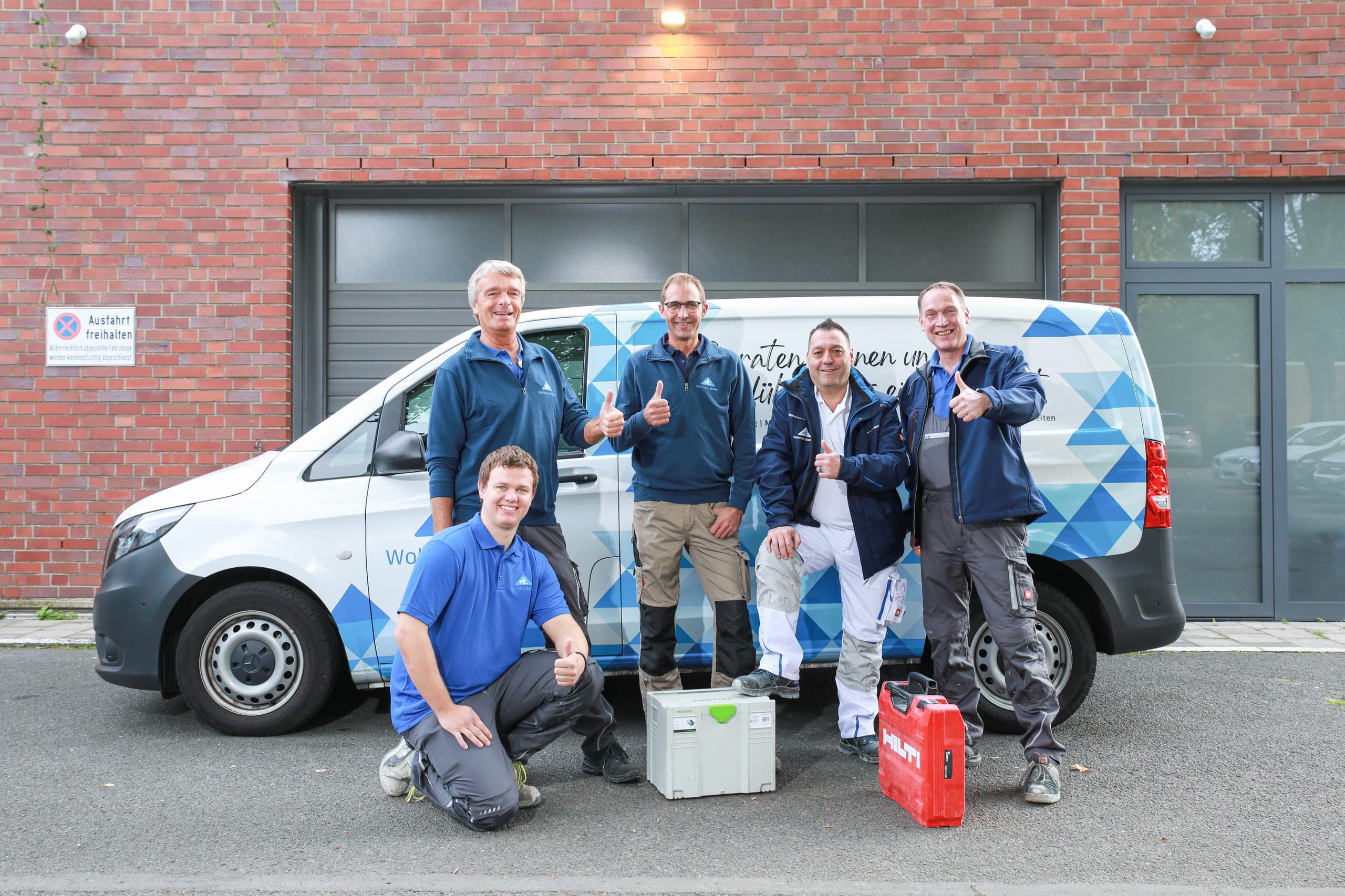 Das Team von Wohnbau Expert vor dem Firmentransporter, alle mit Daumen nach oben