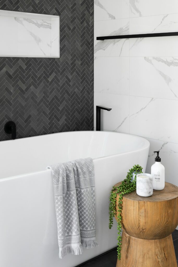 Modernes Badezimmer, weiße Badewanne, schwarze Fliesen. Fliesenleger Münster